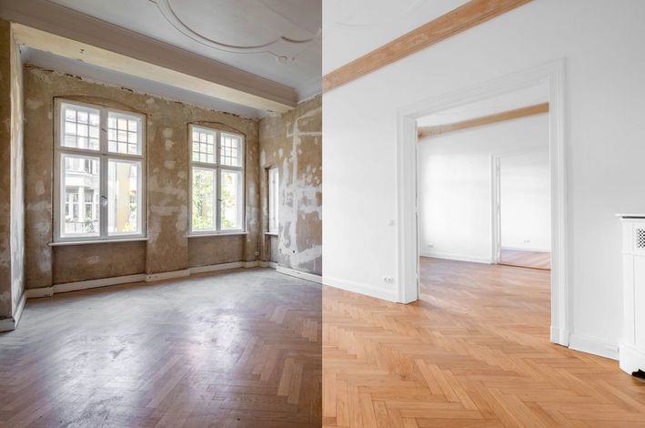 Stanza vuota e luminosa con pavimento in parquet, ampie finestre e porta bianca.
