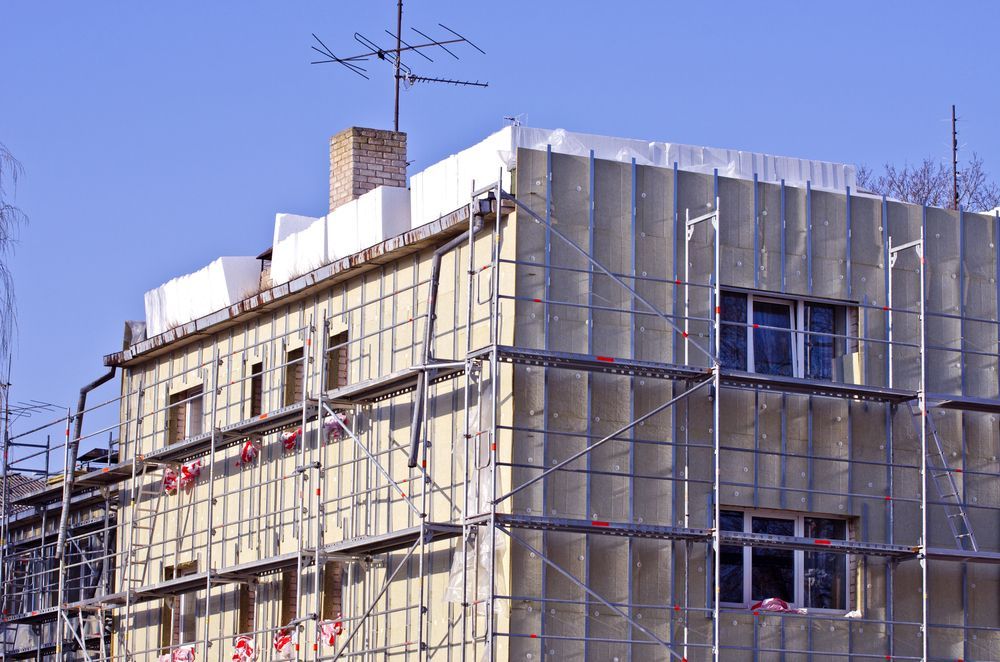 Impalcature attorno a un edificio in costruzione sullo sfondo di un cielo azzurro.