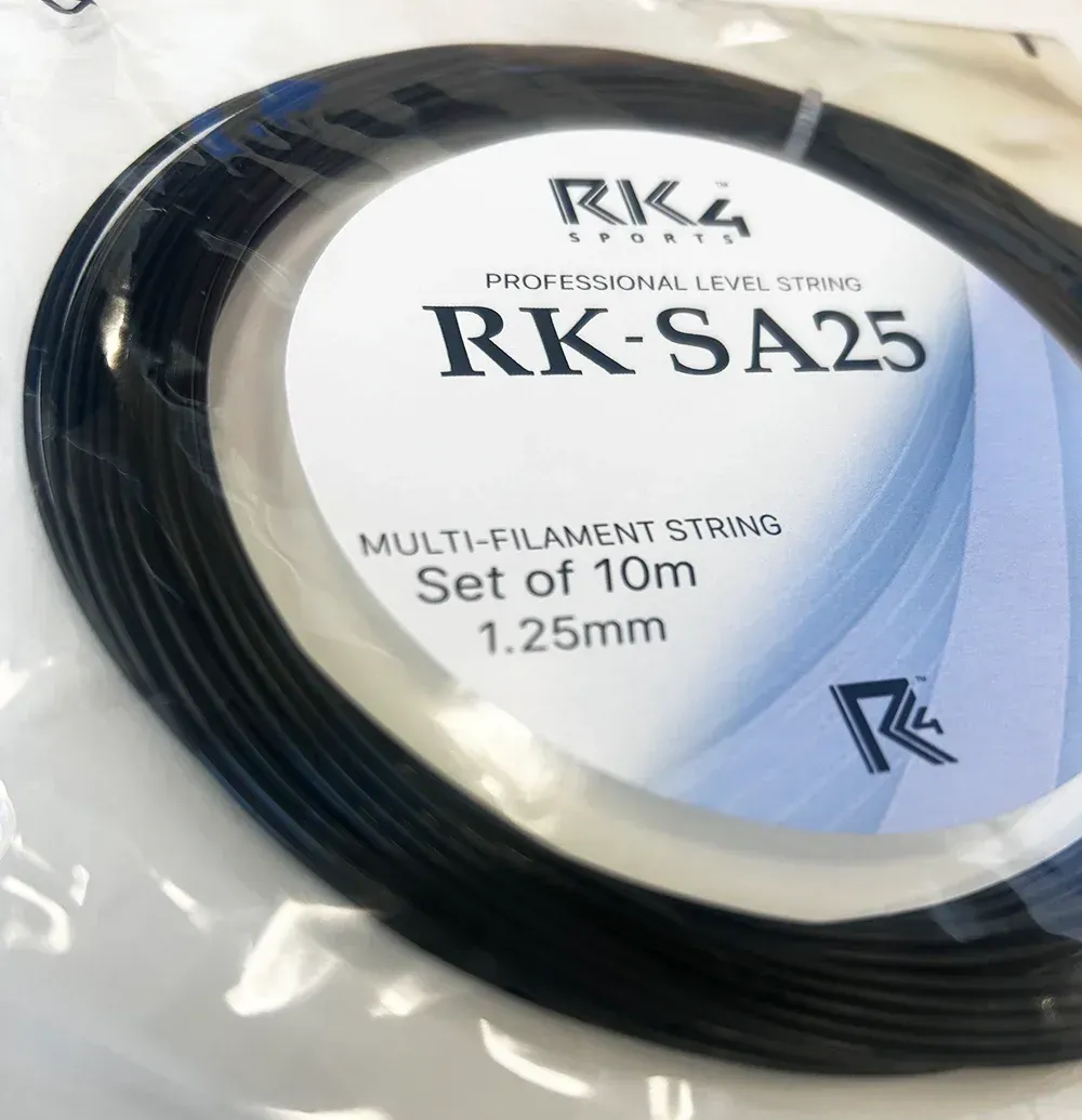 Black badminton string, RK-SA25, coiled in a clear plastic bag. White label with product details.