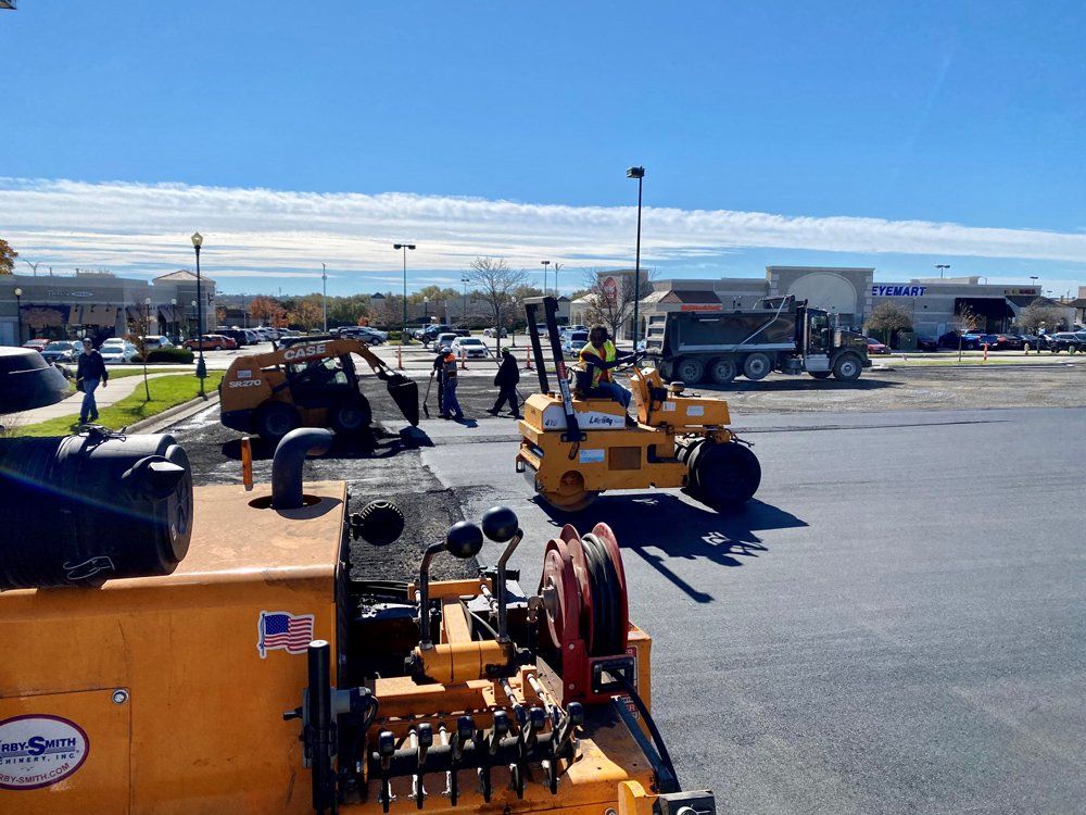 Orange construction equipment parked in a lot under a clear blue sky