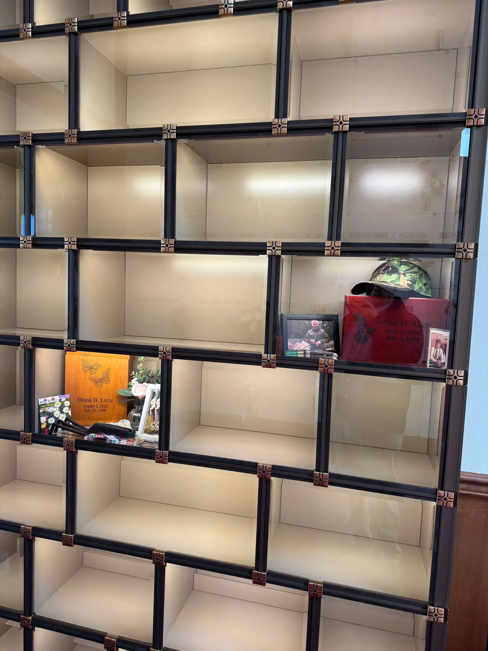 Empty grid shelf with dark trim, holding a few decorative items.