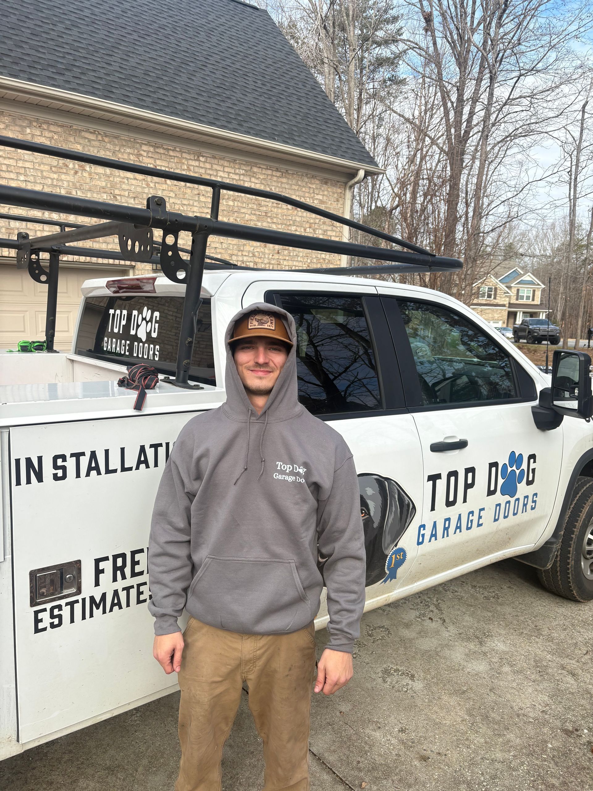 Man in hoodie stands near a work truck, 