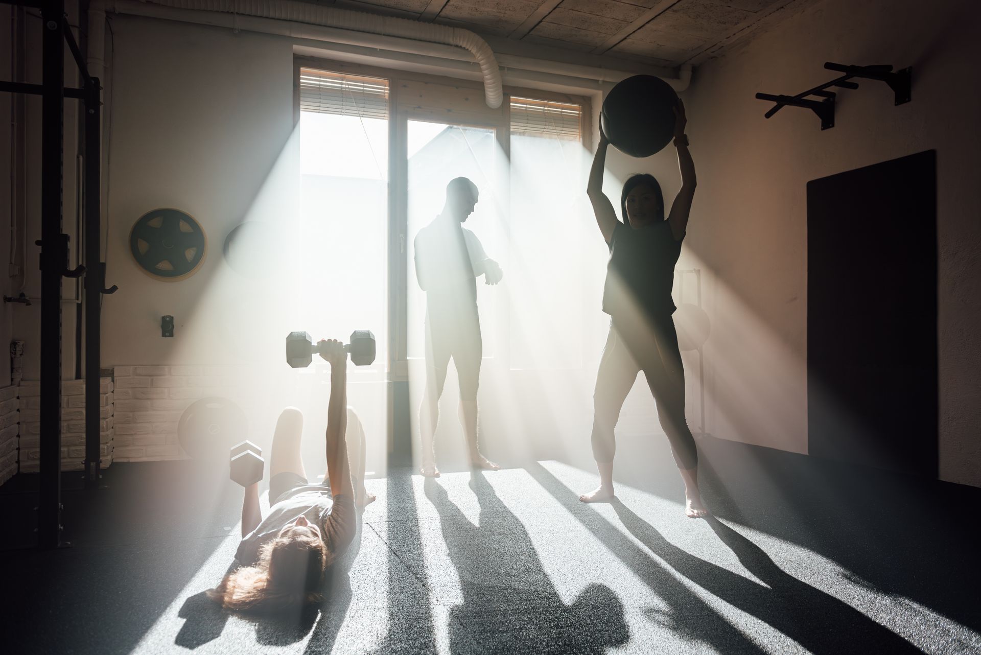 A man and a woman are doing exercises in a gym.