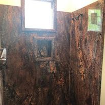 A bathroom with a shower stall and a window.