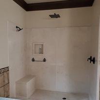 A bathroom with a shower and a bench.