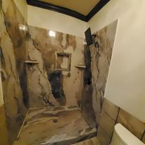 A bathroom with a walk in shower and a toilet.