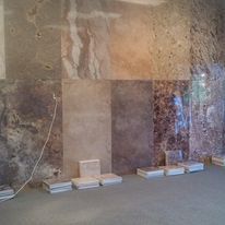 A room with a lot of tiles on the floor and a wall.