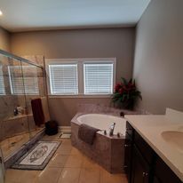 A bathroom with a tub , sink , and shower.