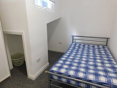 a bedroom with a bed and a laundry basket .