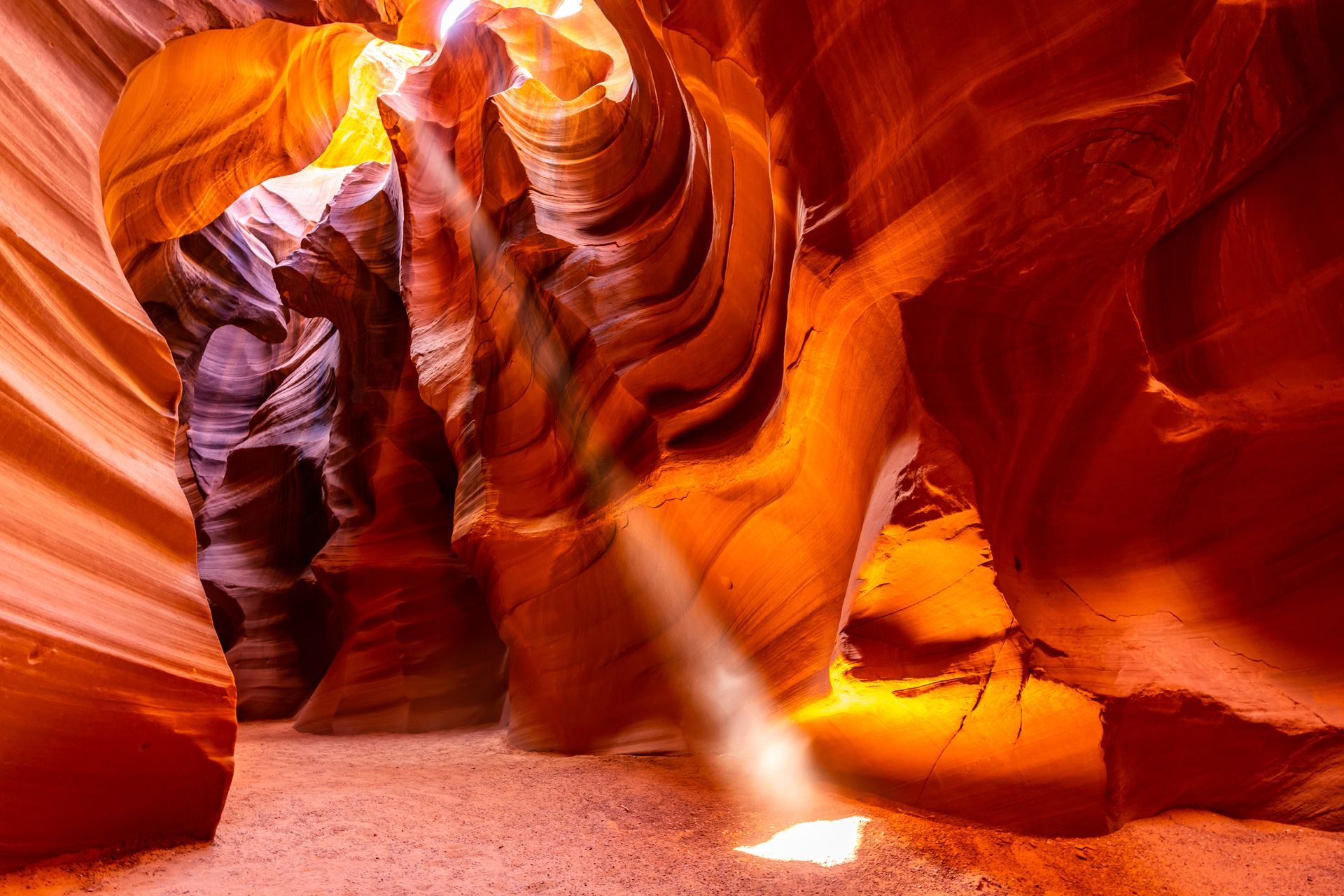 A light is shining through the walls of a canyon.