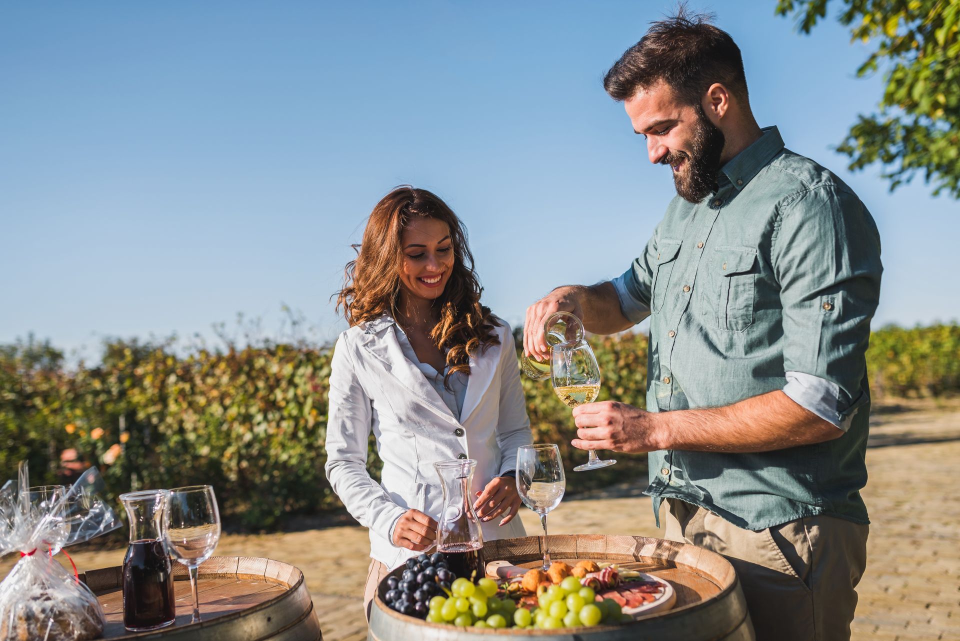 A man is pouring wine into a glass for a woman.