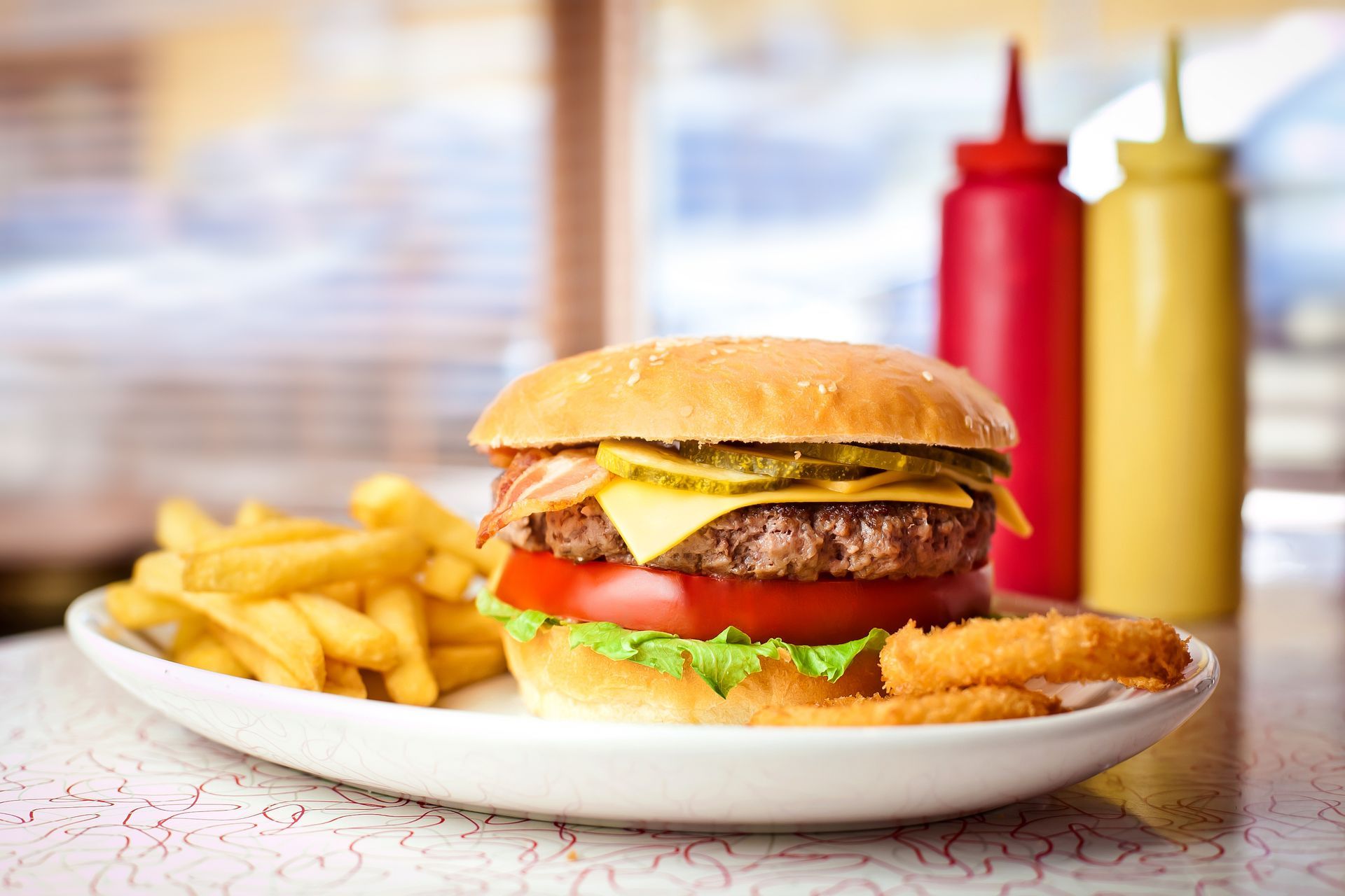 A hamburger and french fries on a white plate on a table.