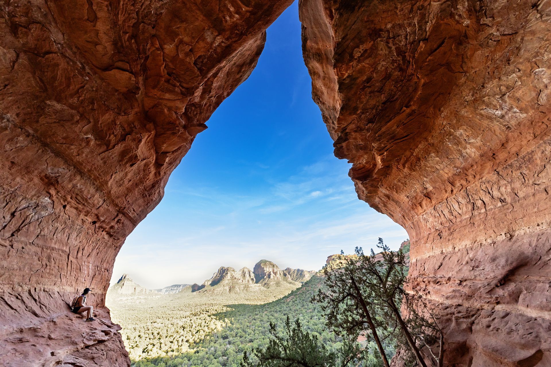 A view of a valley through a hole in a rock formation.