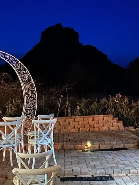A patio with chairs and a crescent moon in the background