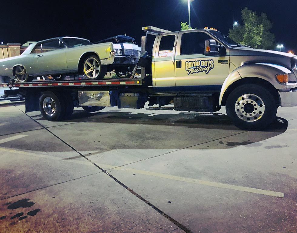 A tow truck with a car on the back of it