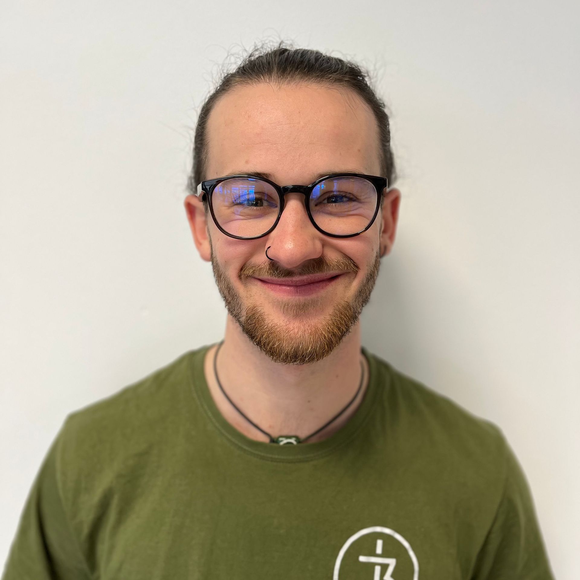Ein Mann mit Brille und grünem Shirt lächelt in die Kamera.