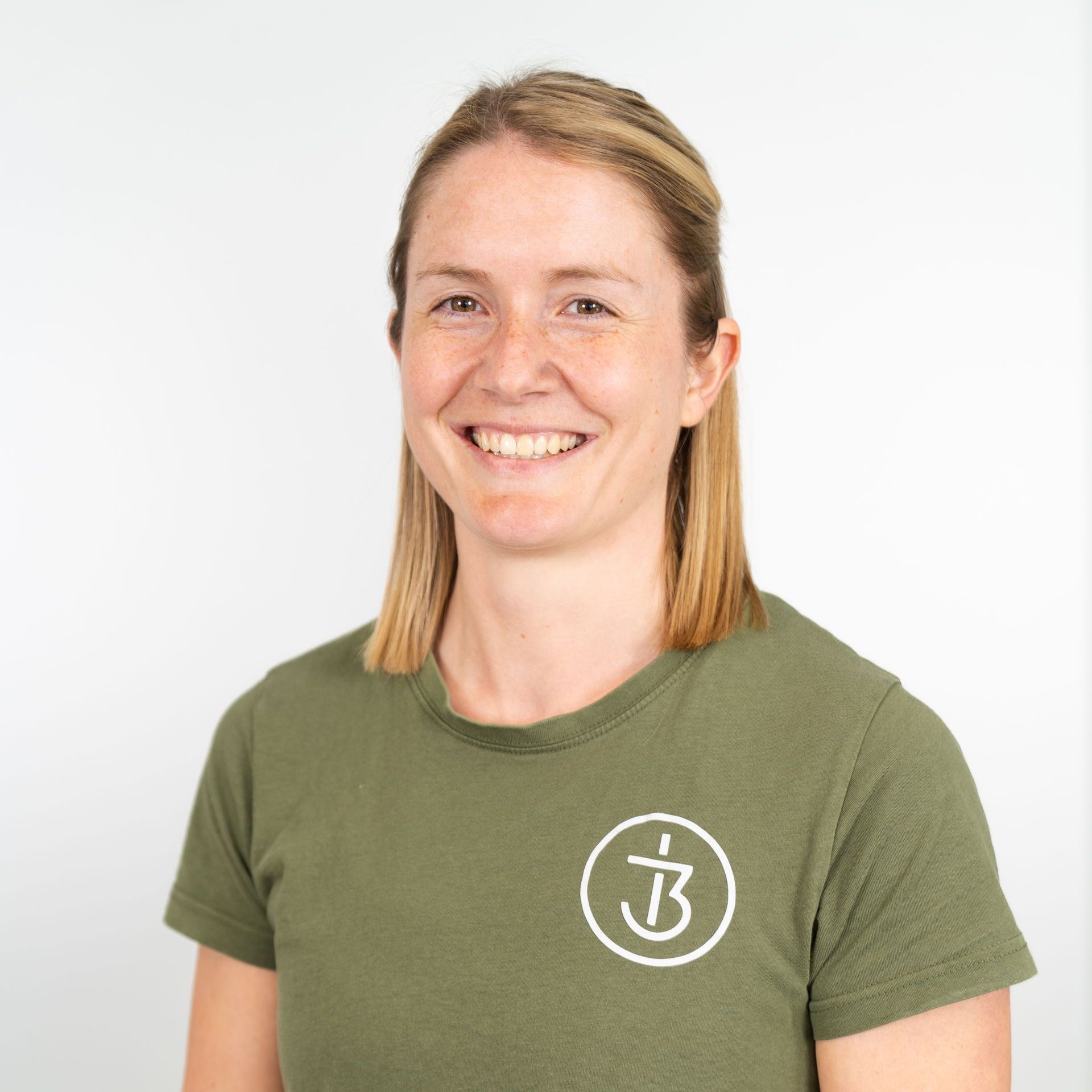 Eine Frau, die ein grünes Shirt mit dem Therapie3 Logo darauf trägt