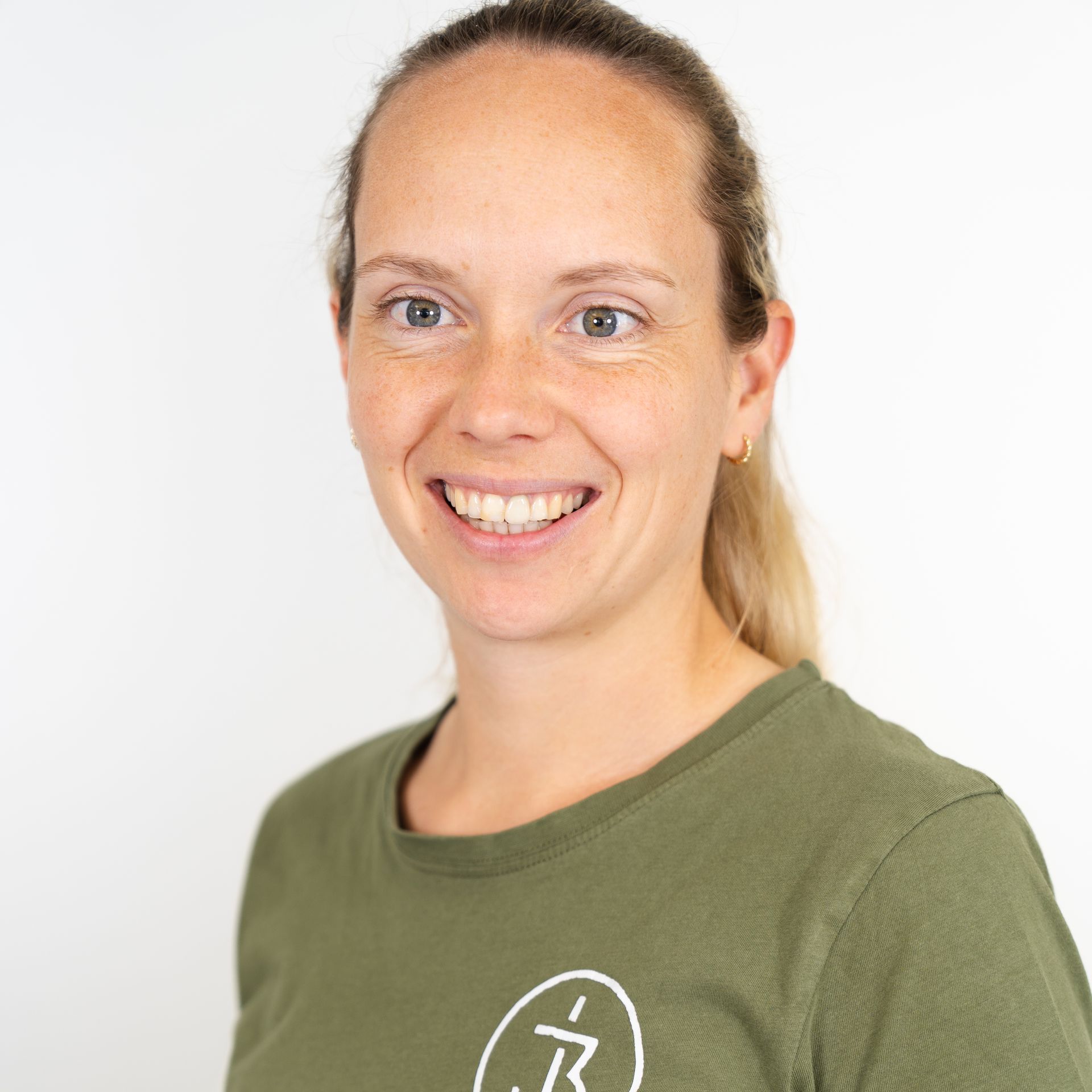 Eine Frau in einem grünen Shirt lächelt in die Kamera.