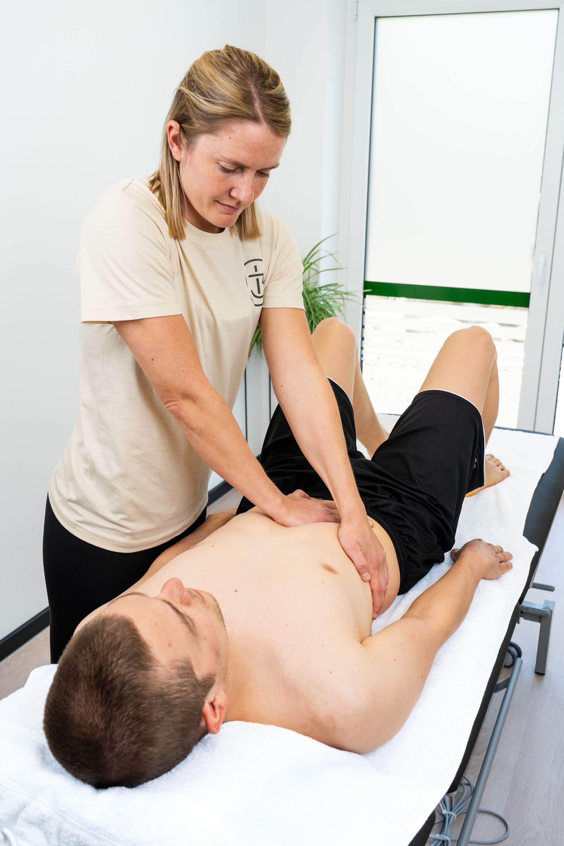 Eine Frau gibt einem Mann auf einem Tisch eine Massage.