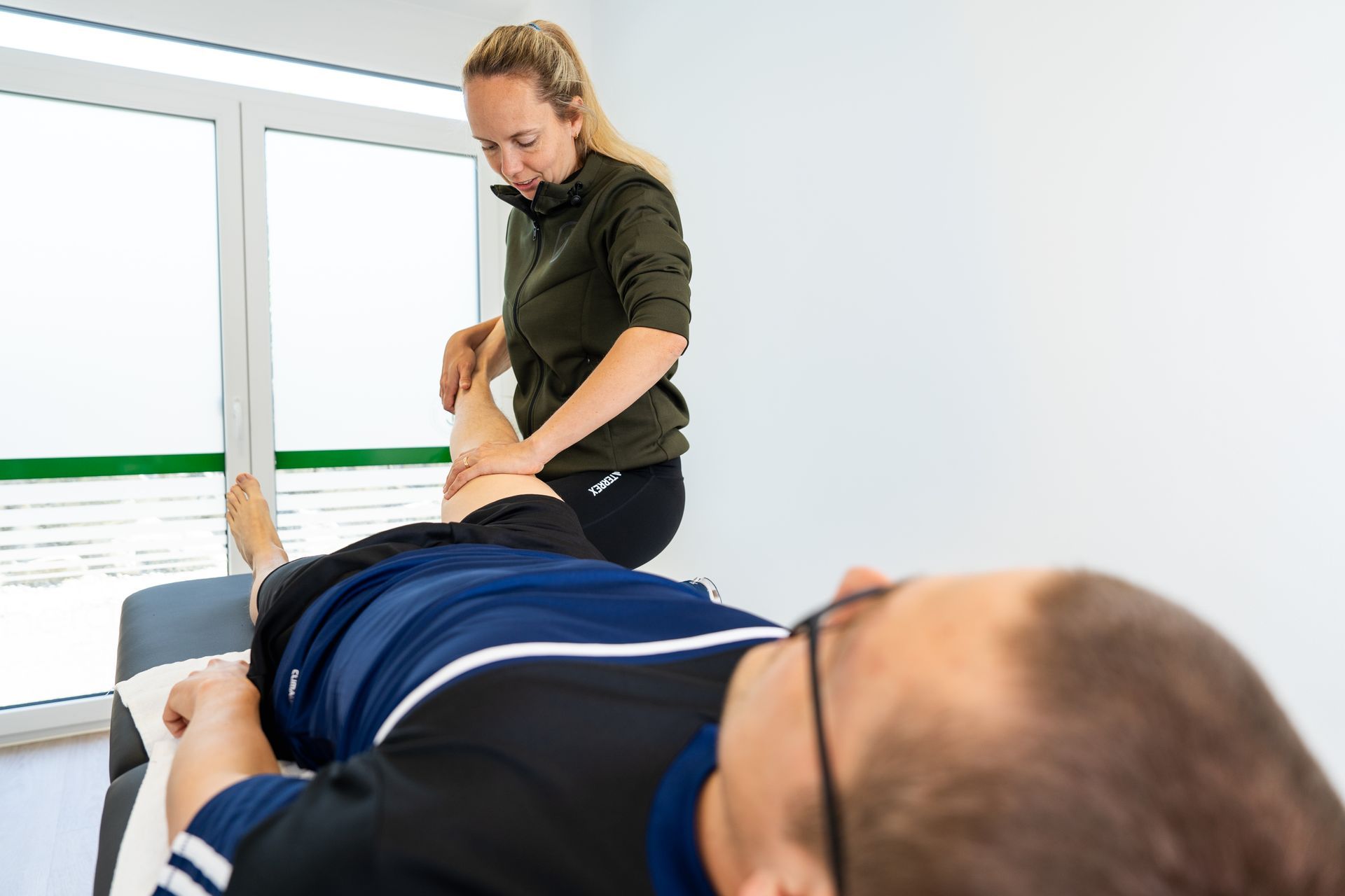 Eine Frau gibt einem Mann auf einem Tisch eine Massage.