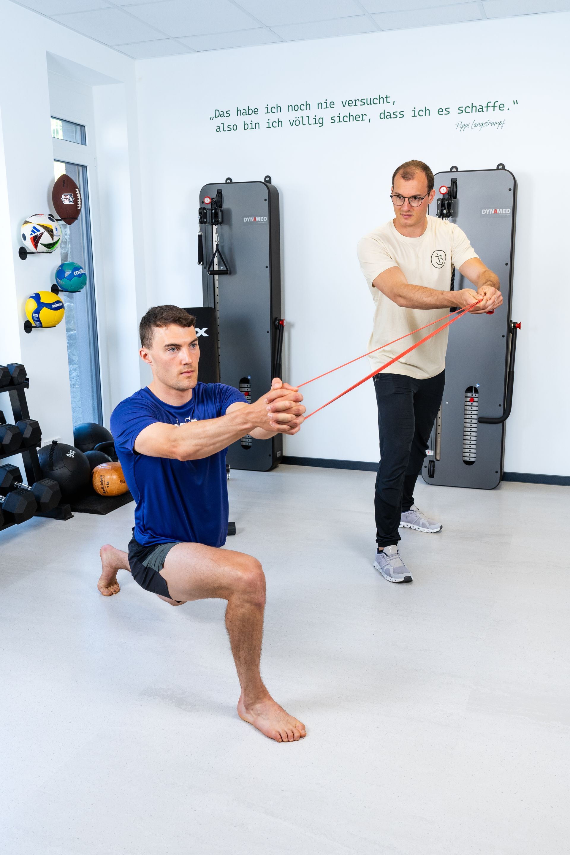 Ein Mann macht in einem Fitnessstudio Kniebeugen mit einem Widerstandsband.