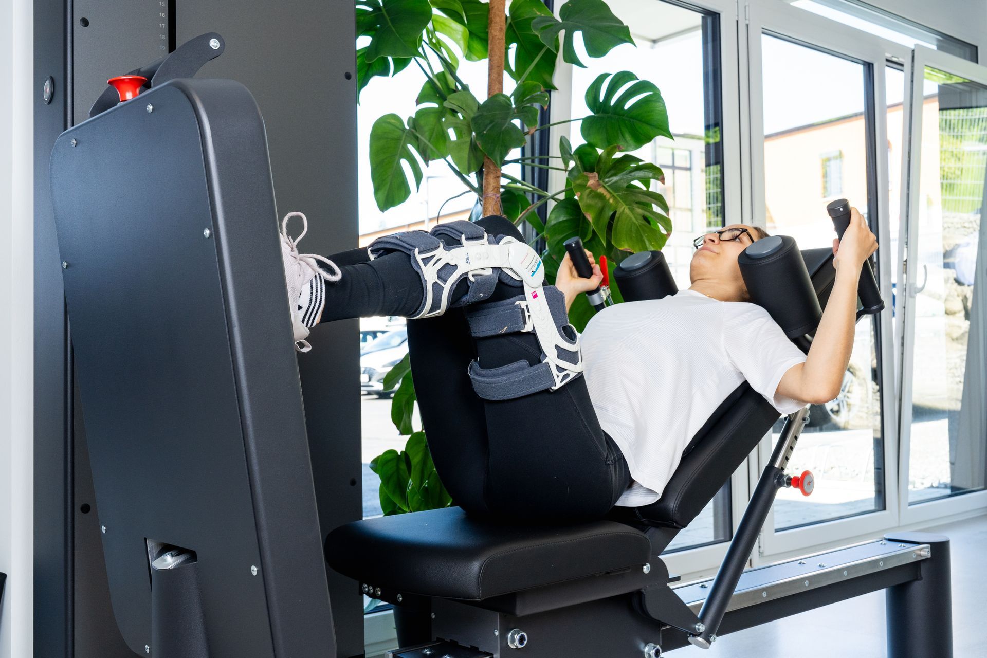Eine Frau trainiert in einem Fitnessstudio auf einem Gerät.