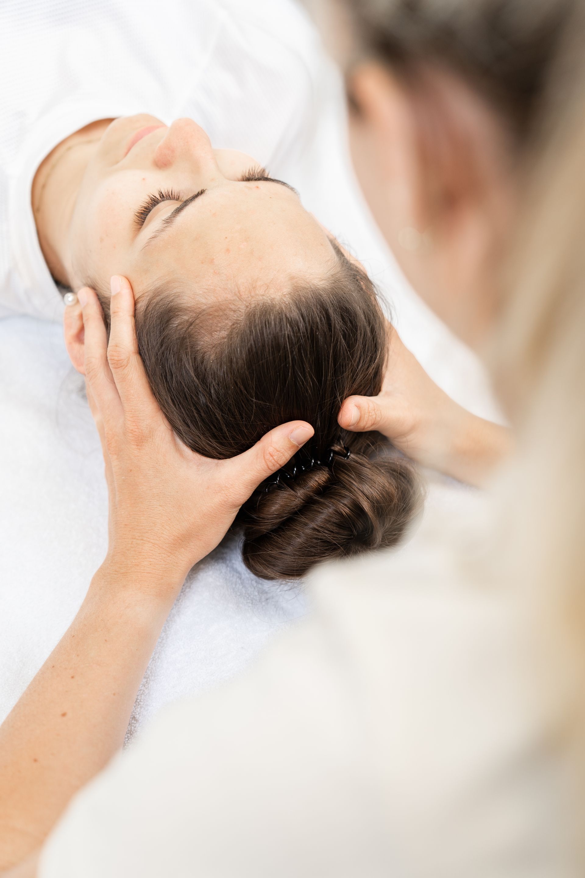 Eine Frau bekommt eine Kopfmassage.