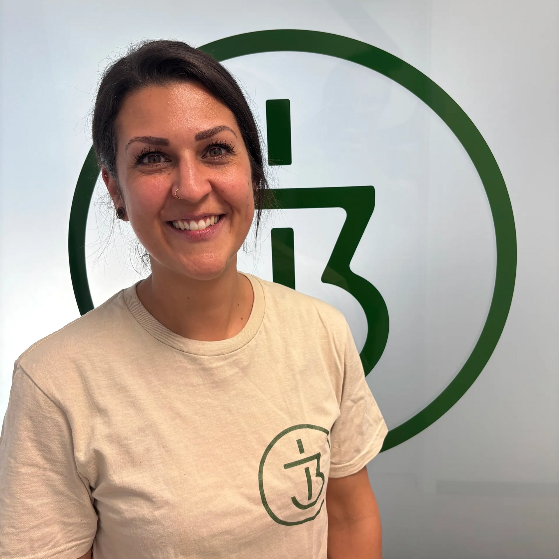 Eine Frau in einem grünen Shirt lächelt in die Kamera.