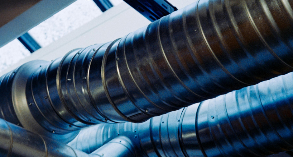 Industrial silver metal ventilation ducts running across a ceiling.