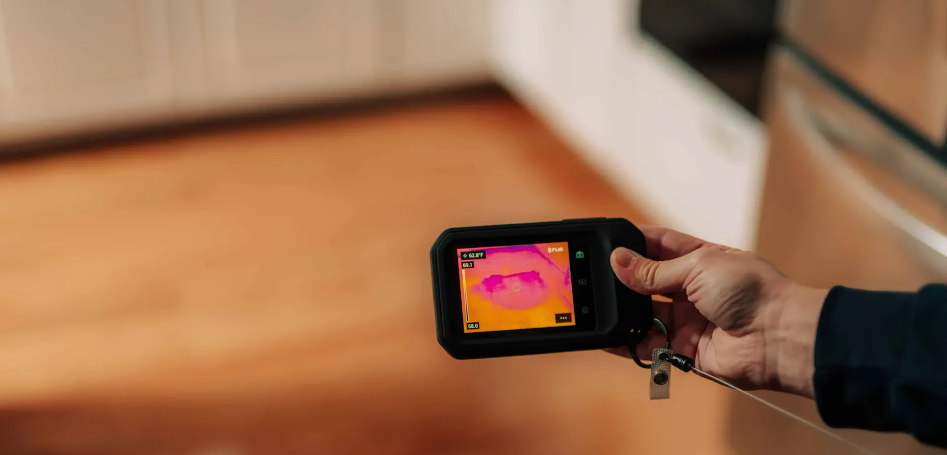 A person is holding a thermal camera in their hand.