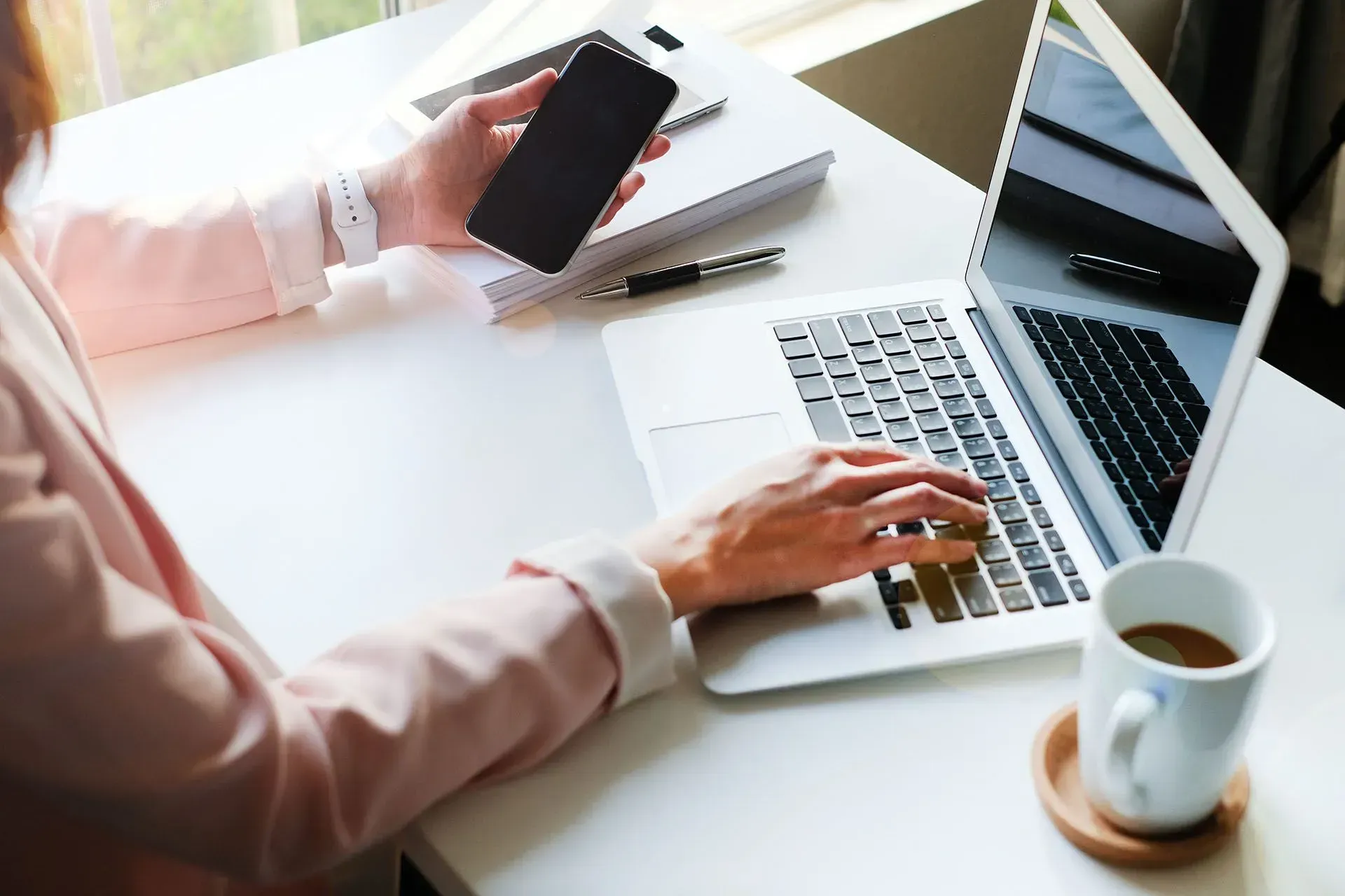 Woman Using a Smartphone and Laptop