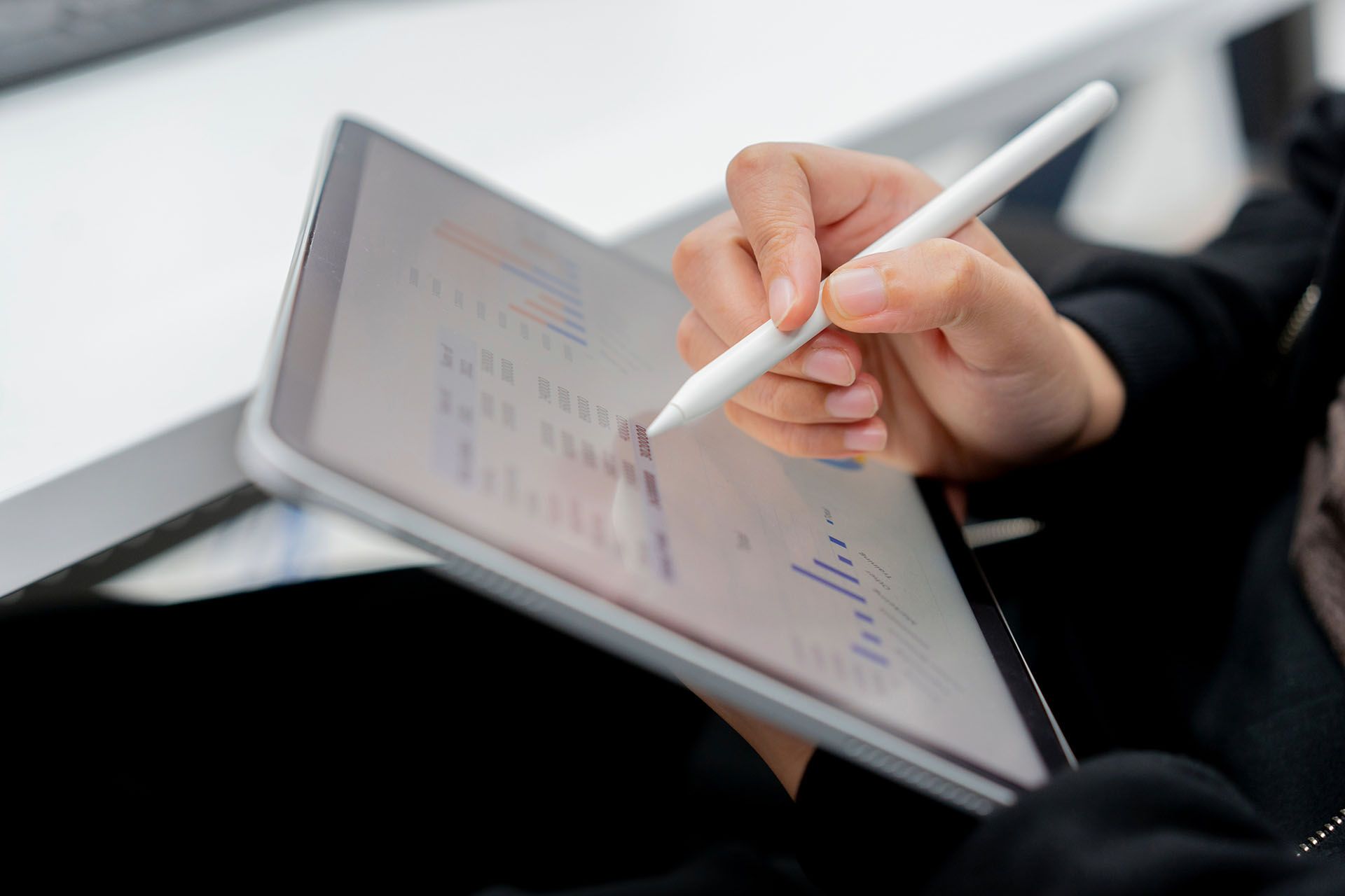A person is writing on a tablet with a pen.