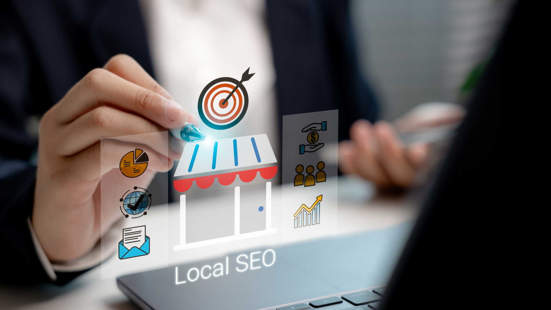 Digital graphic of a storefront with icons representing Local SEO, floating above a laptop while a person holds a stylus.