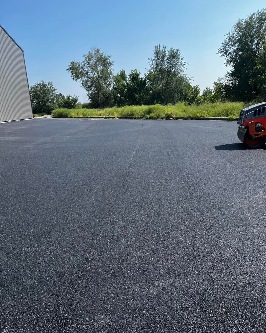 A car is parked in a parking lot with a building in the background