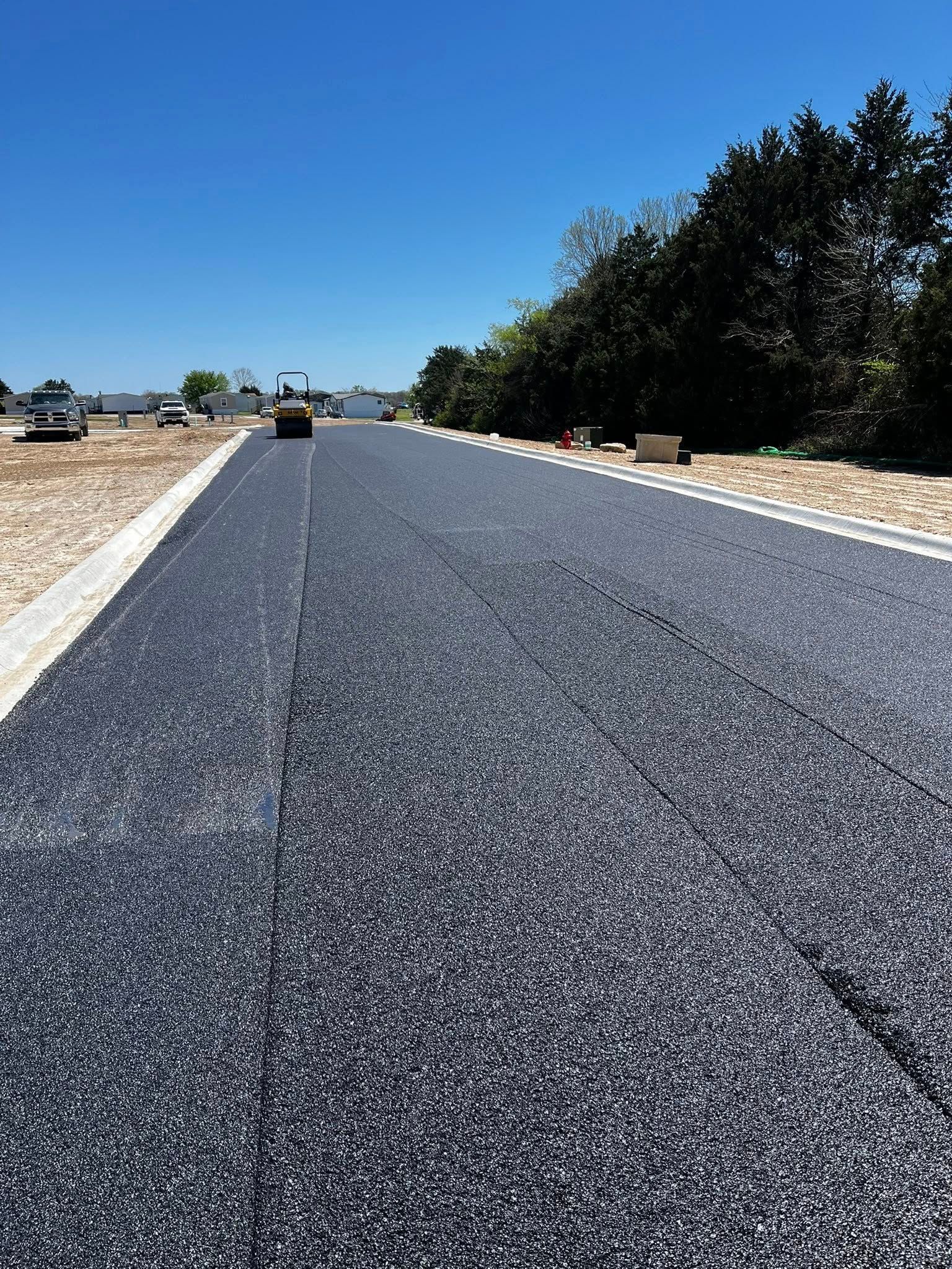 A car is driving down a newly paved road.