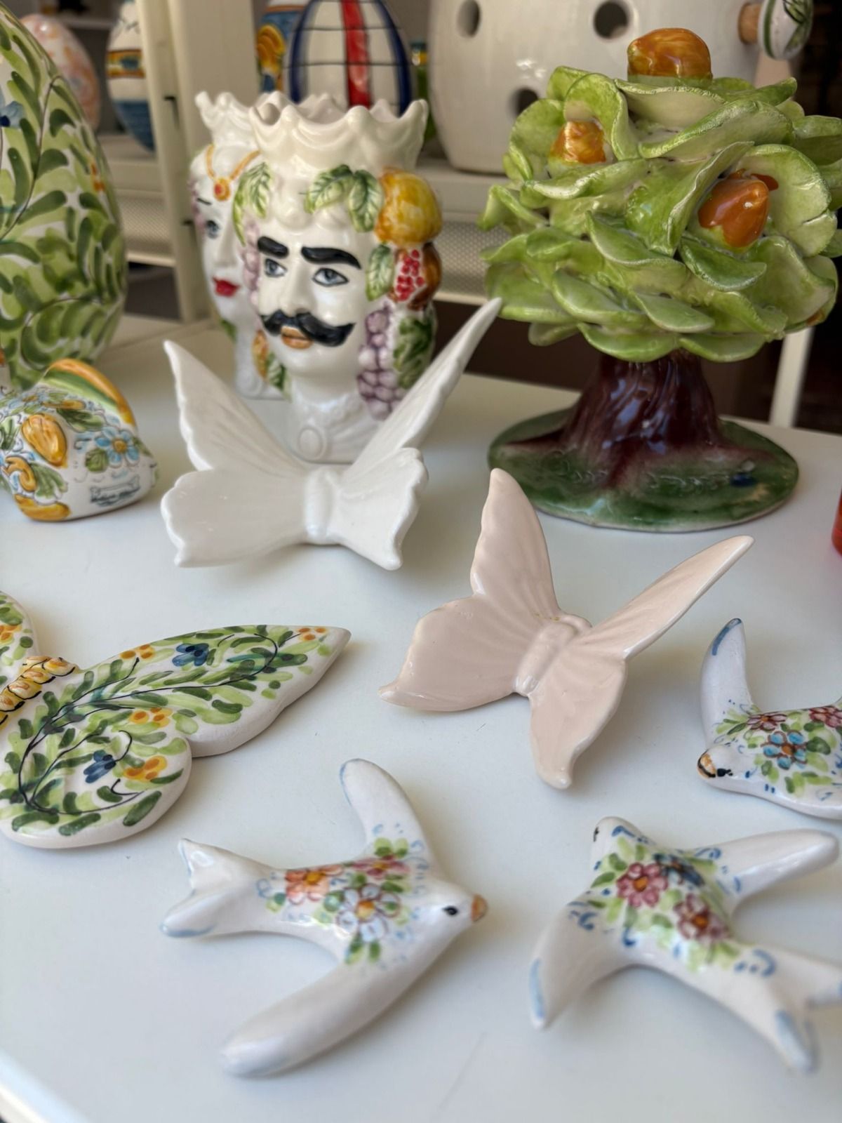 Decorazione raffigurante un melograno arancione con semi rossi, appeso a un albero di Natale verde.