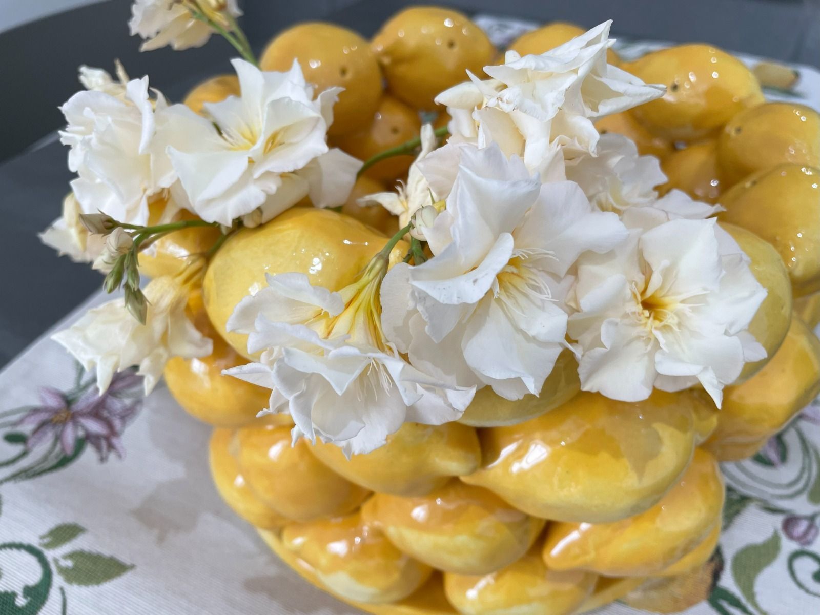 Torta al limone decorata con fiori bianchi.