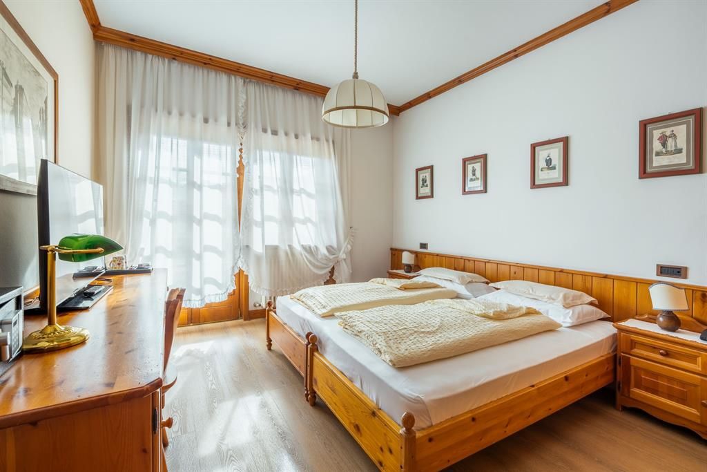 Ein Hotelzimmer mit zwei Betten, einem Schreibtisch und einem Fernseher.