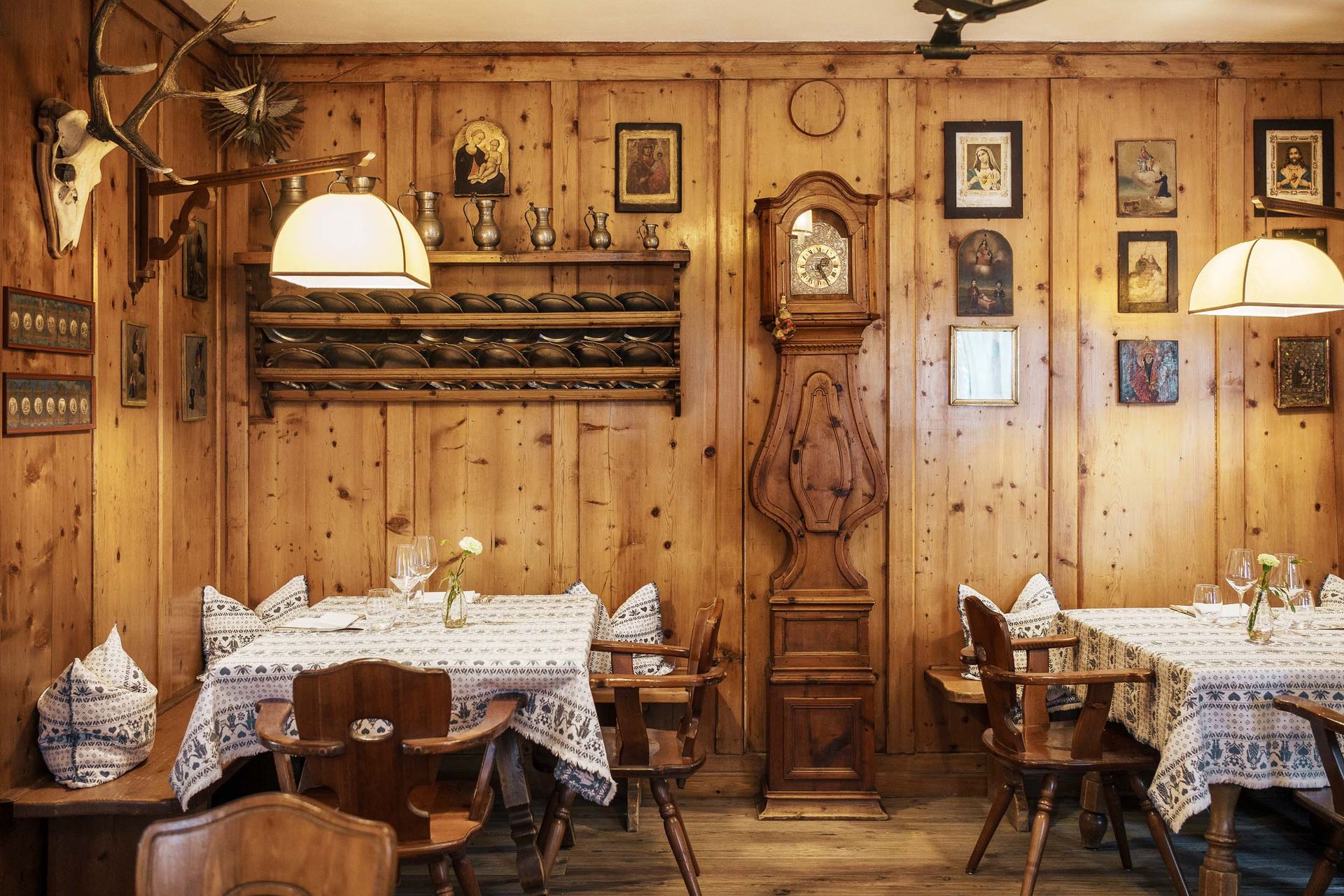 Ein Esszimmer aus Holz mit Tischen und Stühlen und einer Standuhr