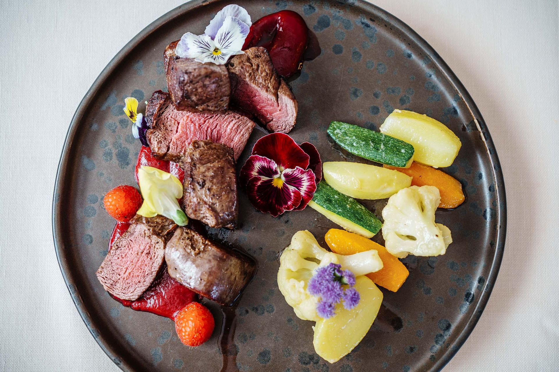Ein Teller mit Fleisch und Gemüse auf einem Tisch.