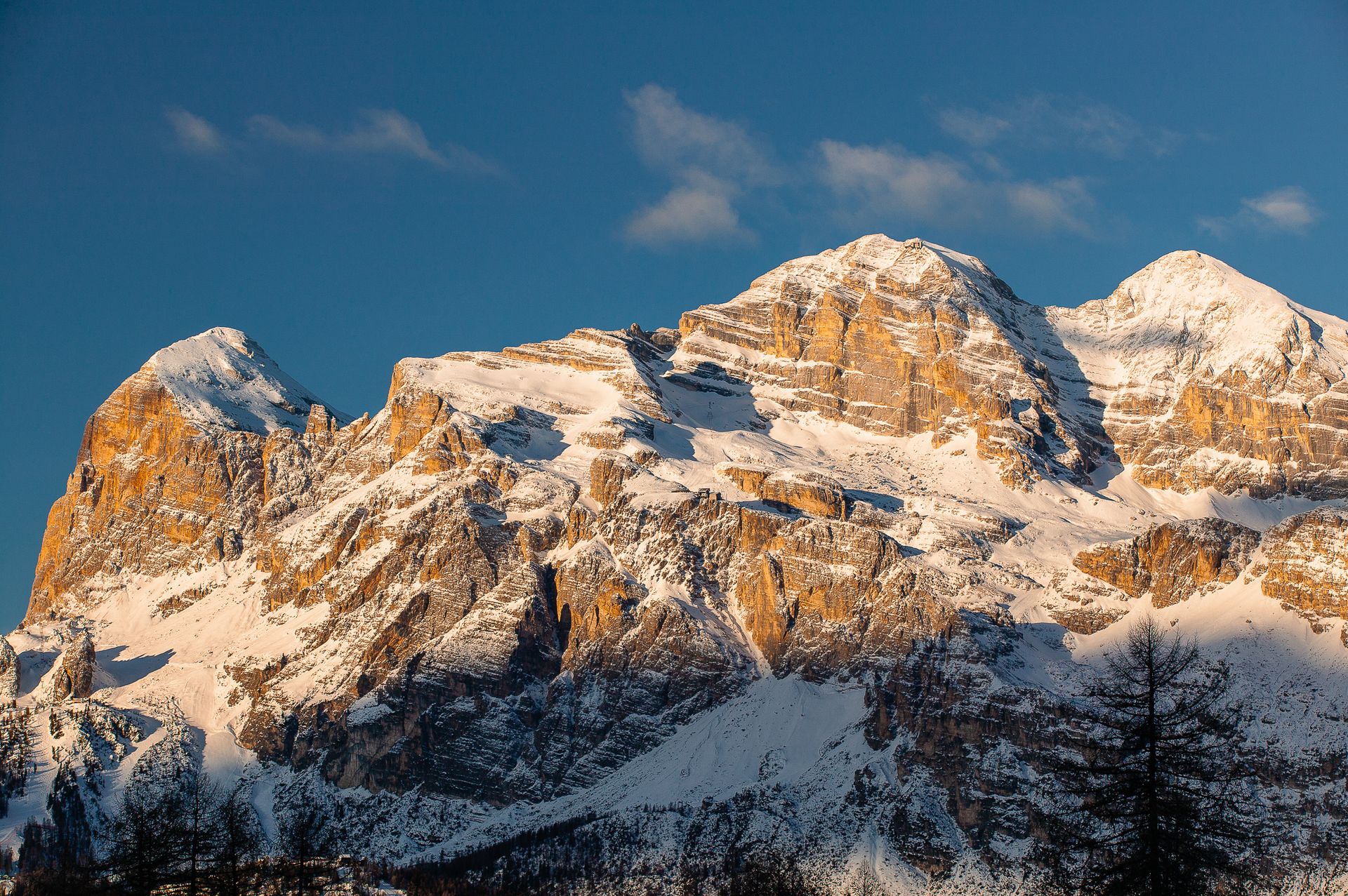 Ein schneebedeckter Berg mit einem blauen Himmel im Hintergrund
