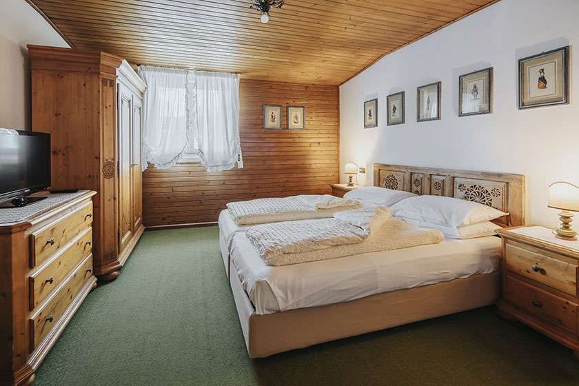 Ein Schlafzimmer mit zwei Betten, einer Kommode und einem Fernseher.