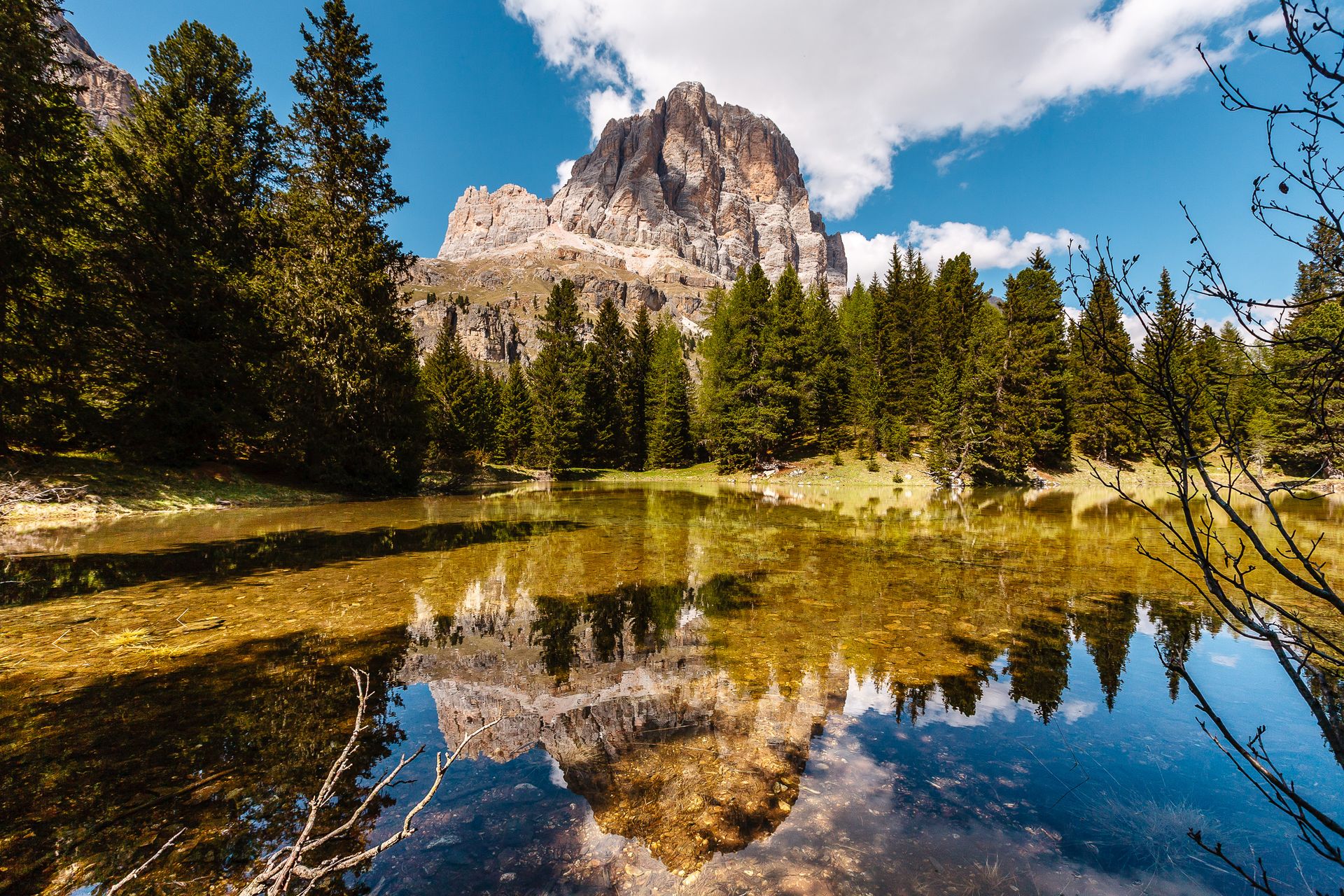 Ein Berg spiegelt sich in einem von Bäumen umgebenen See