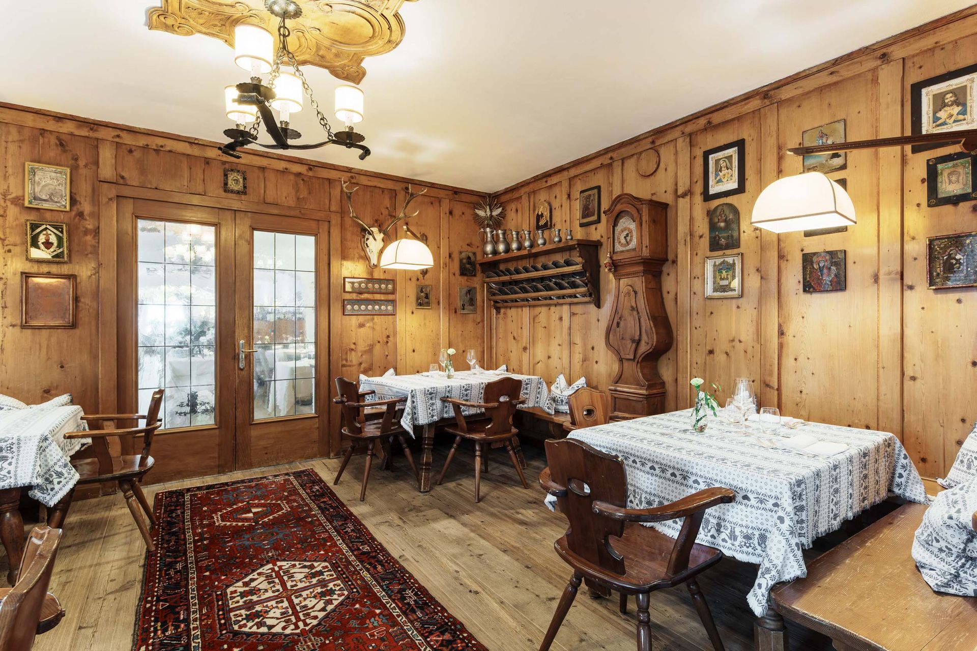 Ein Esszimmer mit Holztischen und -stühlen und einer Uhr an der Wand.