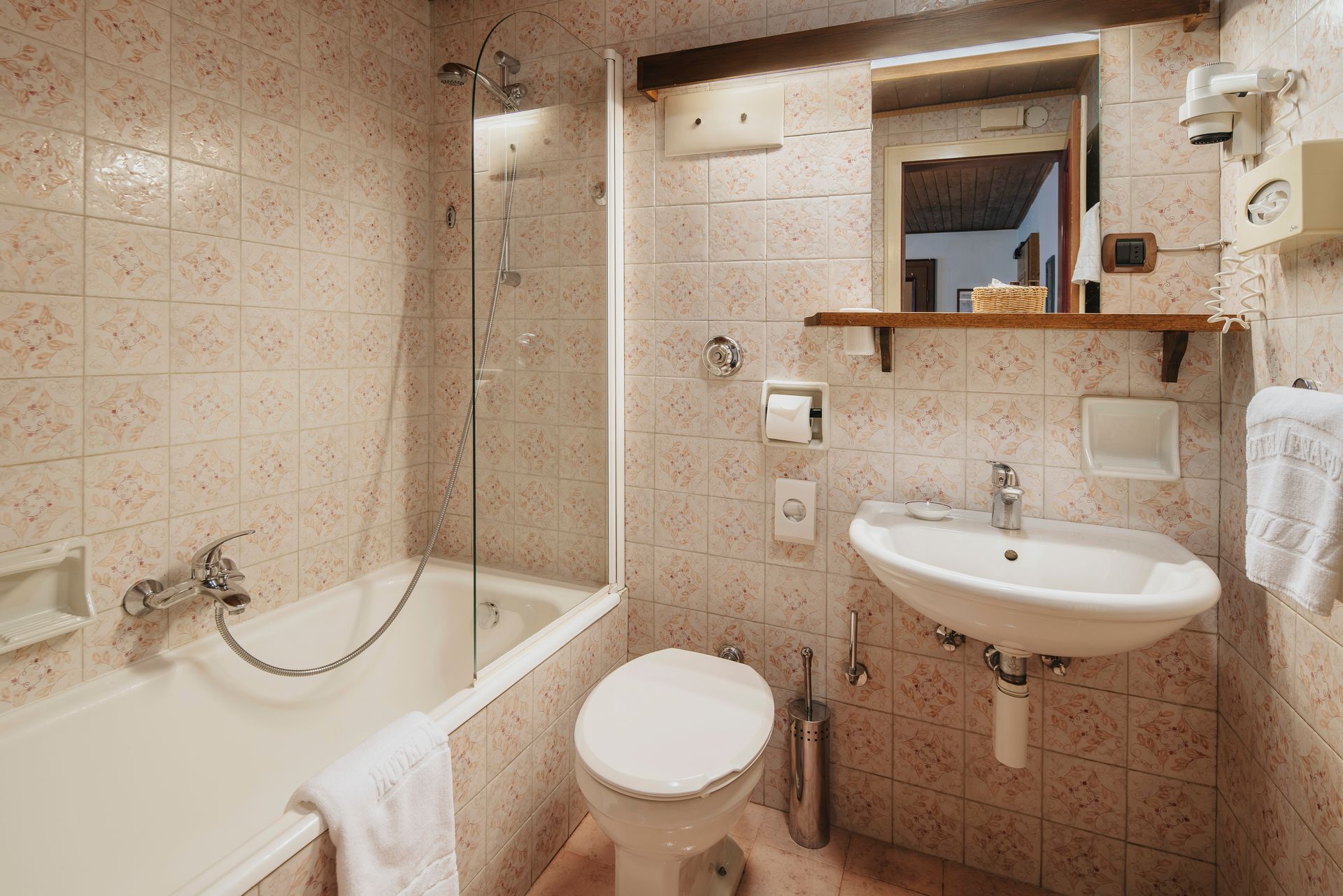 Ein Badezimmer mit Waschbecken, Toilette, Badewanne und Spiegel.