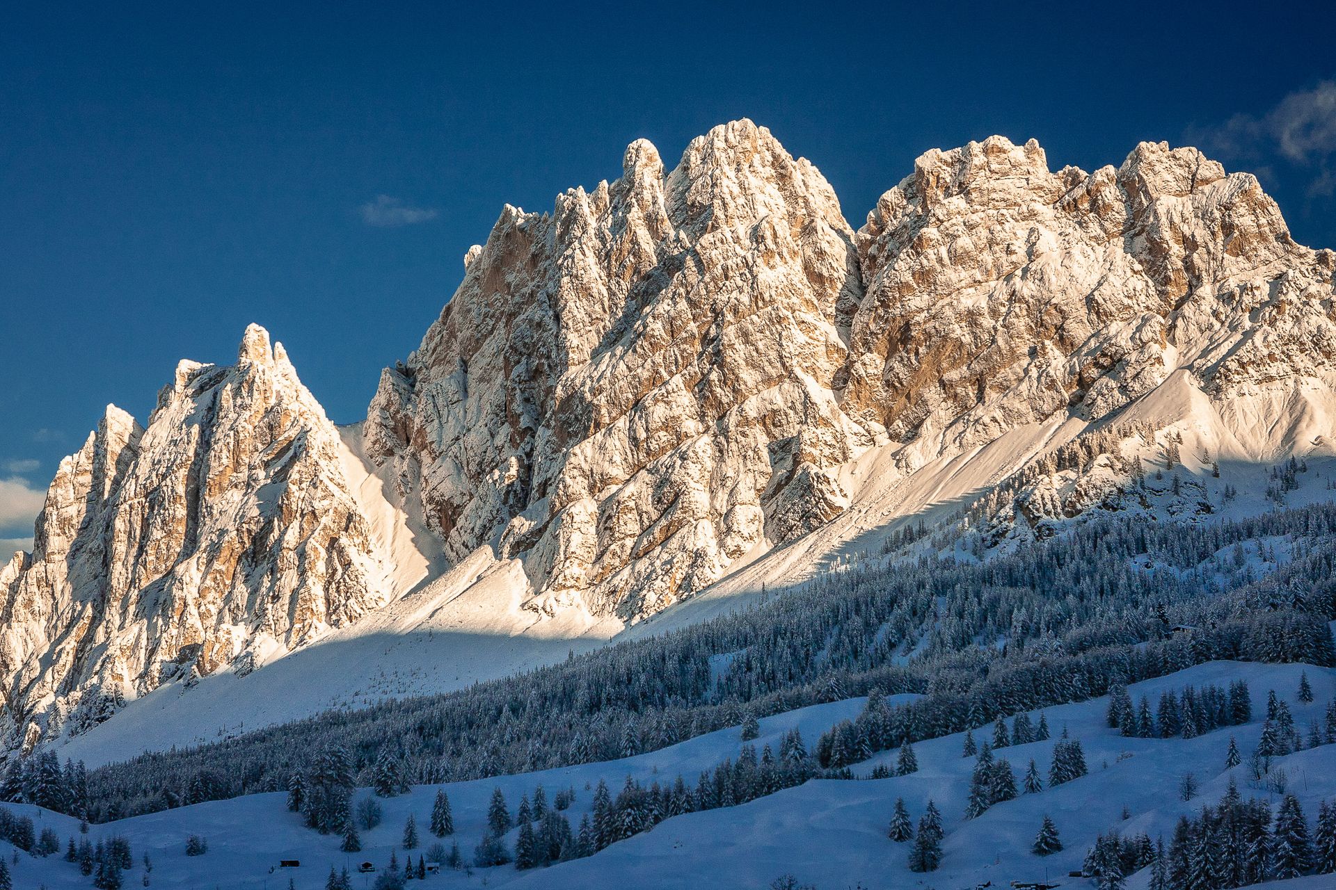 Eine schneebedeckte Bergkette mit einem blauen Himmel im Hintergrund