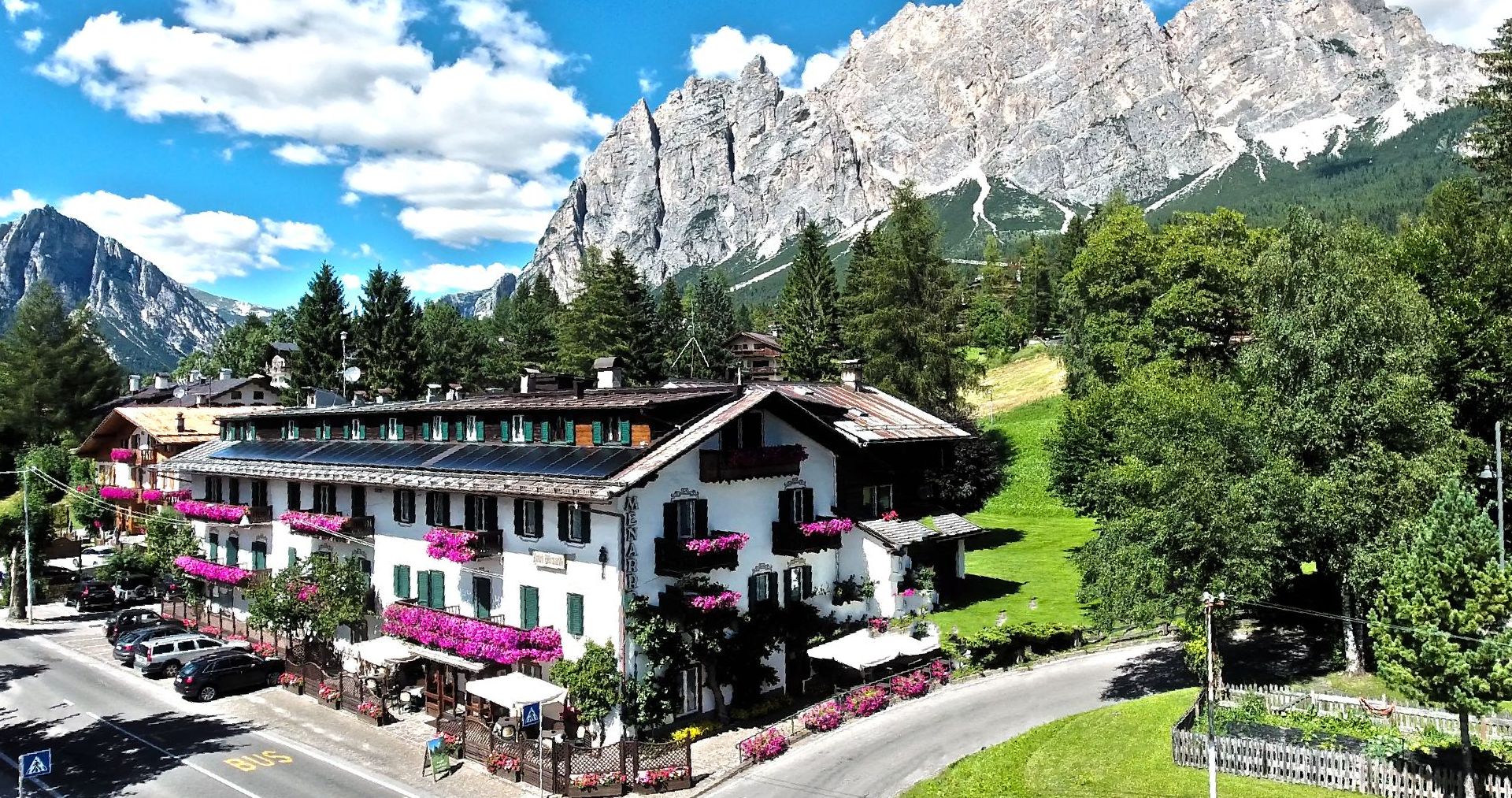 Eine Luftaufnahme Hotel Menardi in den Bergen mit einem Berg im Hintergrund.