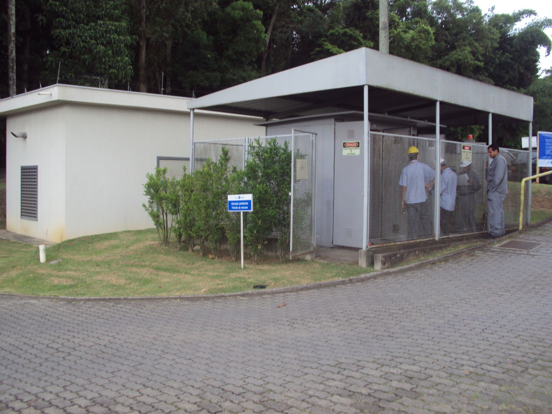 Um grupo de homens está do lado de fora de um prédio