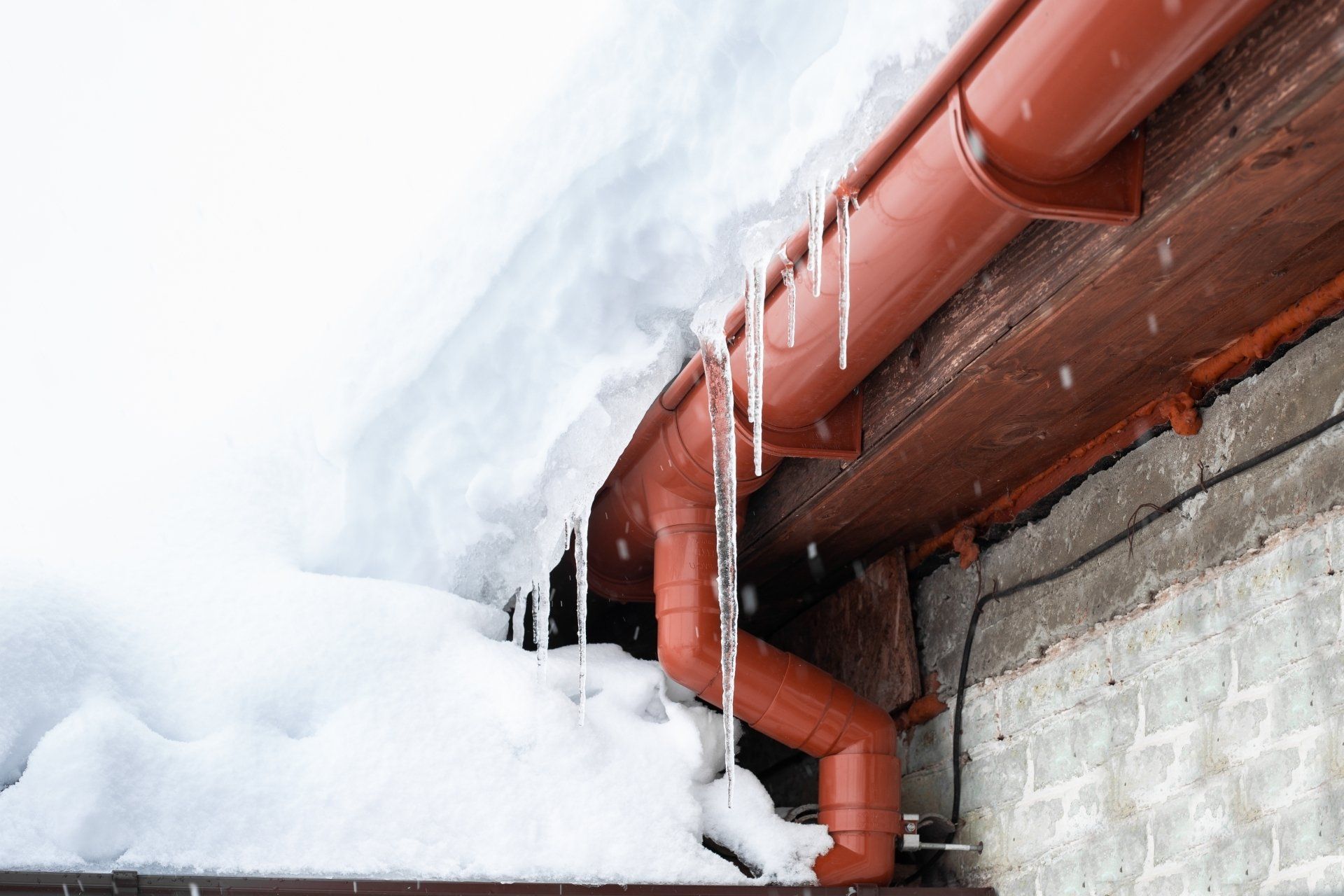 A gutter with snow on it and icicles hanging from it.