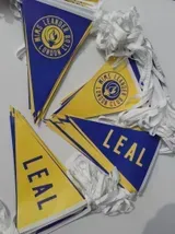 Auf einem Tisch liegen mehrere Dreiecksfahnen mit dem Namen „Leal“.